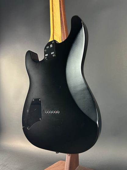 Black electric guitar body on a gray background