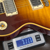 A close-up of a guitar body resting on a digital scale, showing the scale reading 7.17 oz.