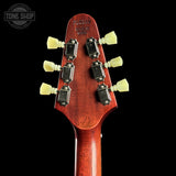 Close-up of the headstock of a guitar against a black background, showing six tuning pegs, metal tuning screws, and a reddish-brown wood finish. A Tone Shop watermark is visible in the top left corner.