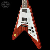 A redwood-finish electric guitar with a white pickguard and black controls, shown against a solid black background with a Tone Shop watermark in the top left corner.