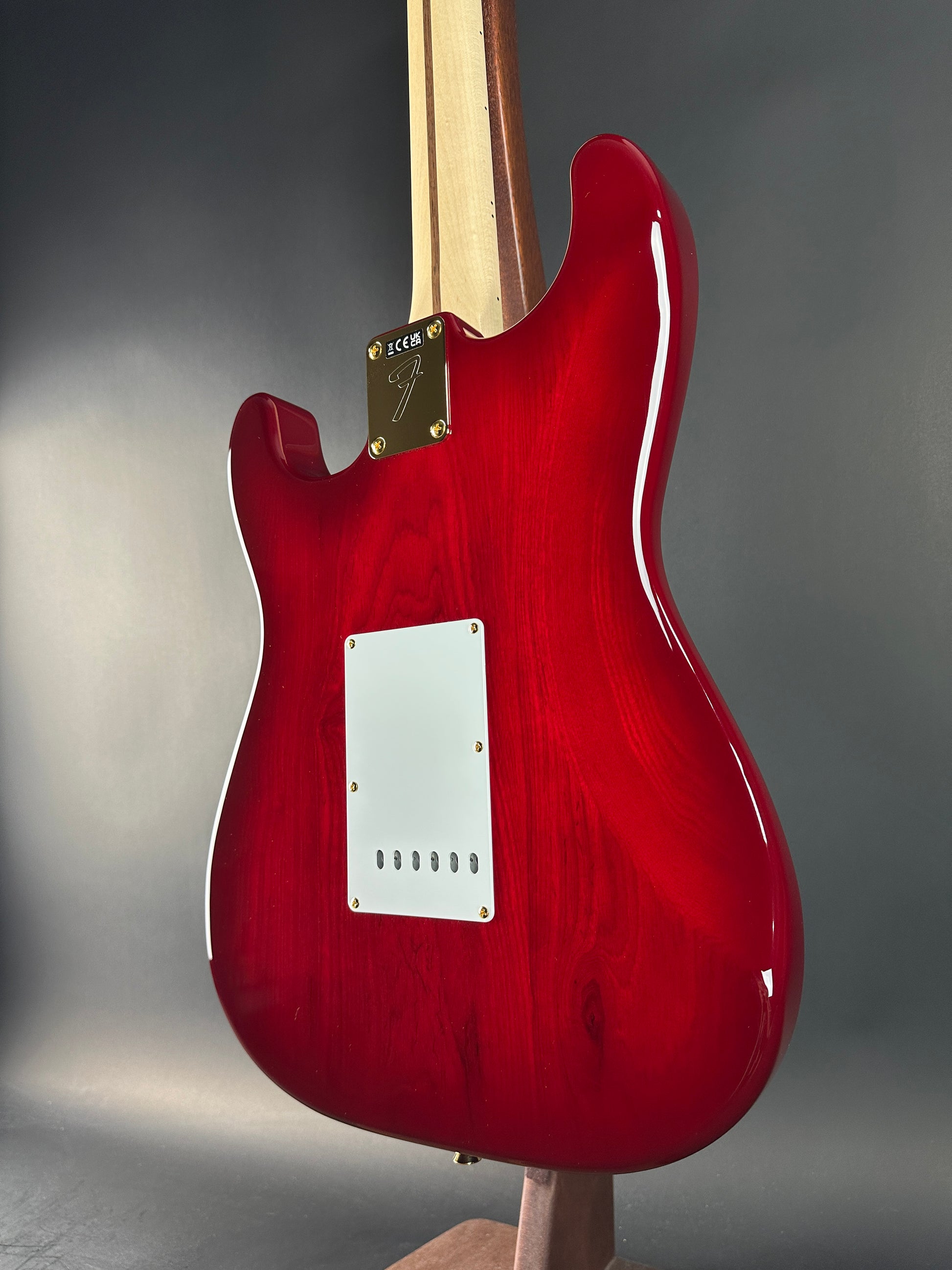 Red electric guitar body on a gray background