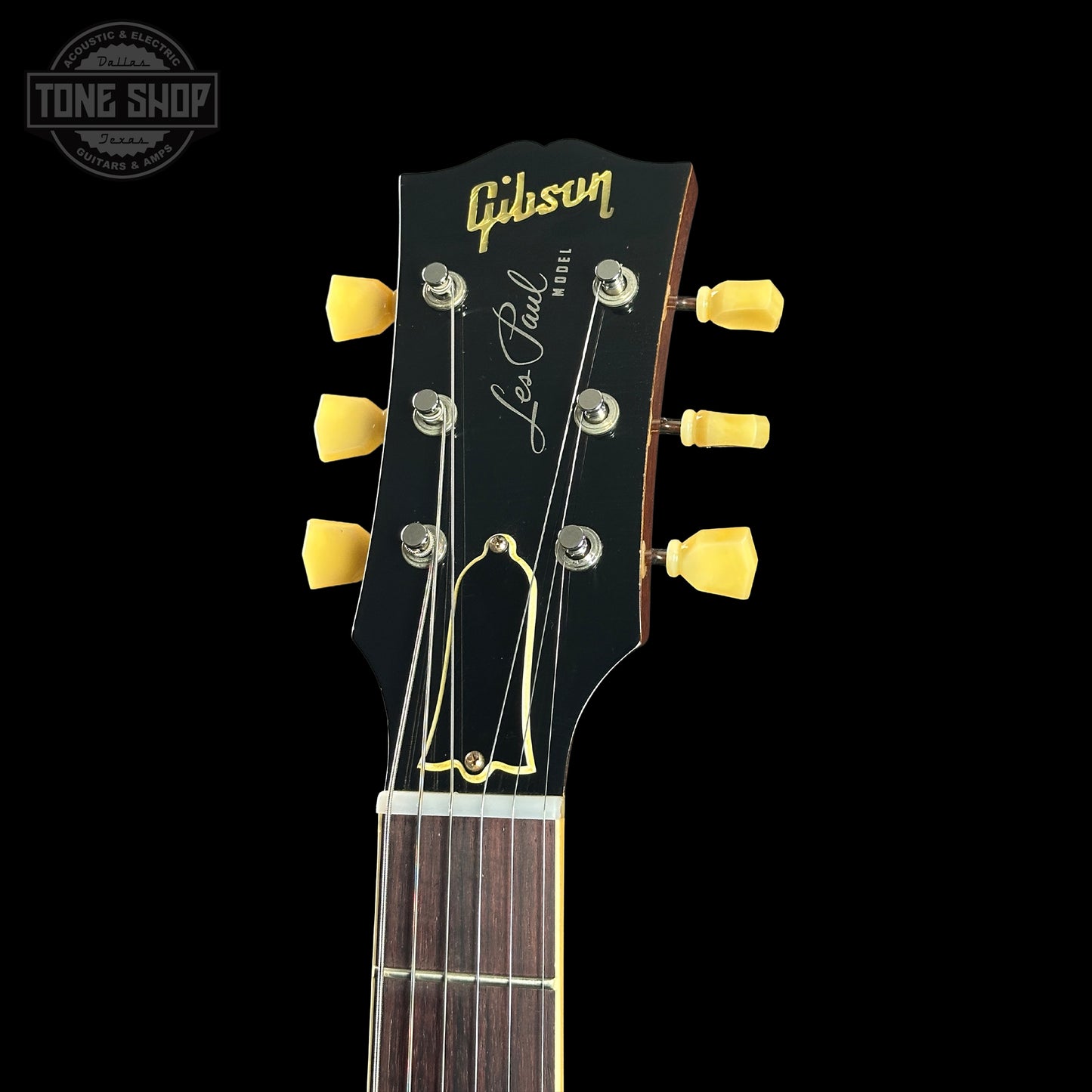Gibson Les Paul guitar headstock with yellow tuning pegs on a black background