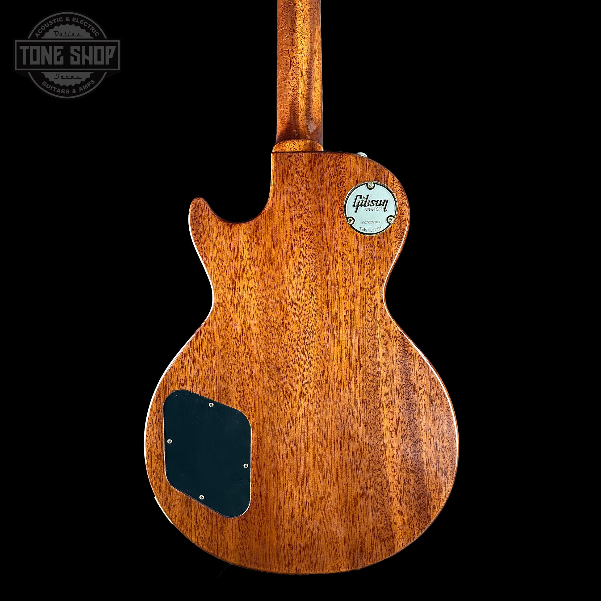 Wooden guitar body with Gibson logo on a black background