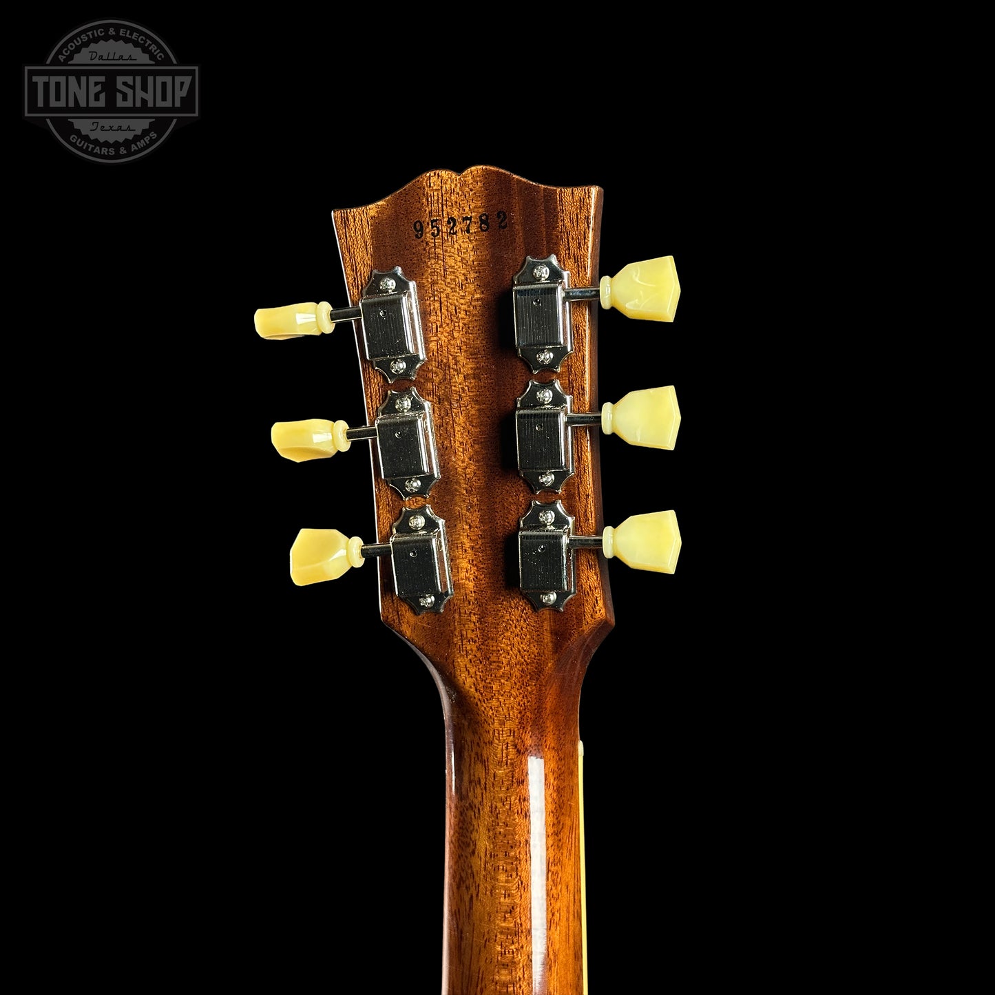 Guitar headstock with tuning pegs on a black background, featuring the Tone Shop logo.