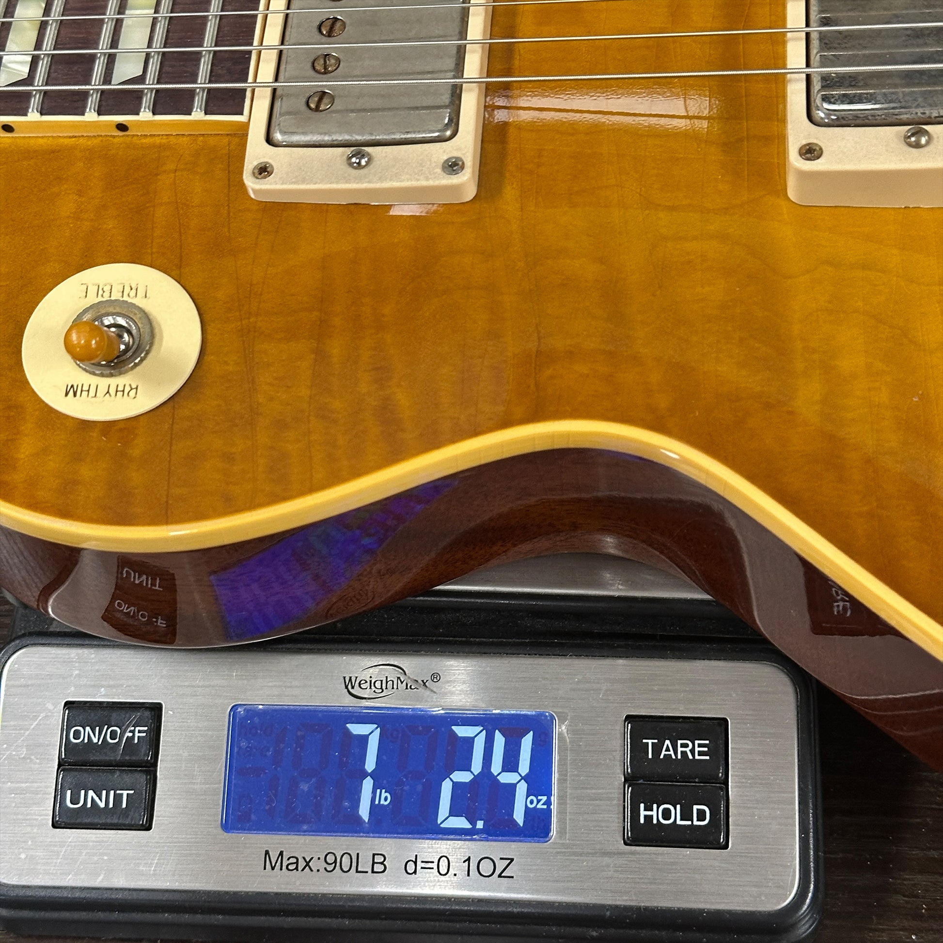 Gibson Les Paul guitar on a digital scale displaying weight