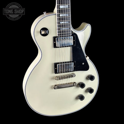 White electric guitar with black details on a black background, featuring 'Tone Shop' branding.