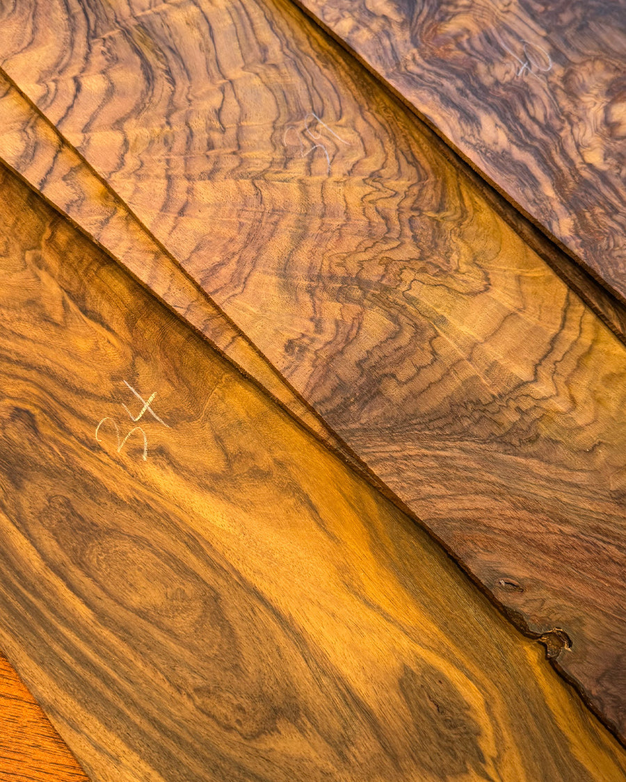 Multiple stacks of figured wood with rich grain figures.