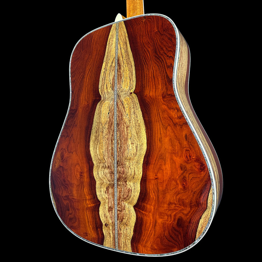Cocobolo back and sides of a martin acoustic guitar against a black background.