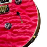 Close-up of a red guitar with visible hardware on a white background
