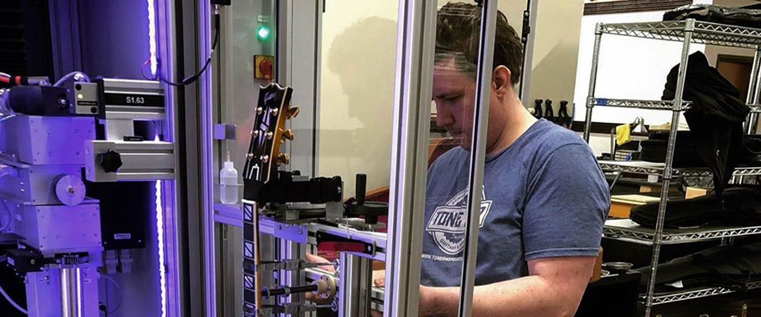 Tone Shop Guitars service tech measuring an electric guitar using Plek.