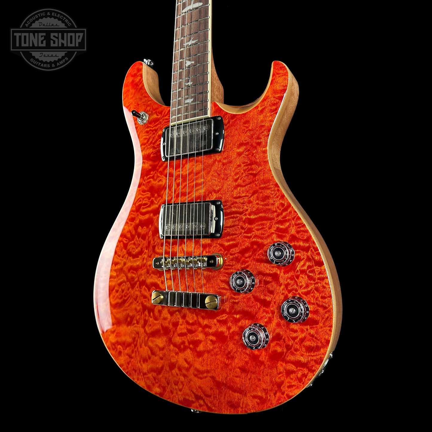 Orange electric guitar with a black background