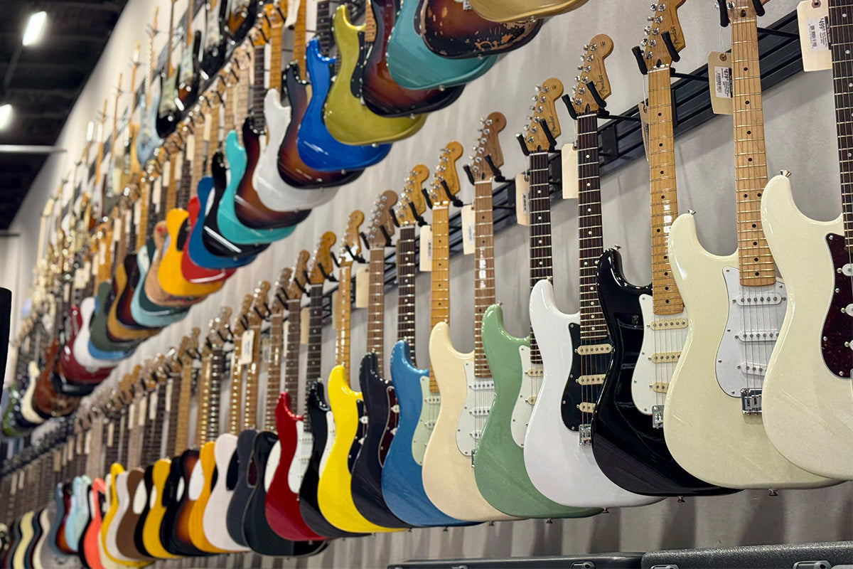 Tone Shop Guitars Southlake wall of electric guitars on hooks.