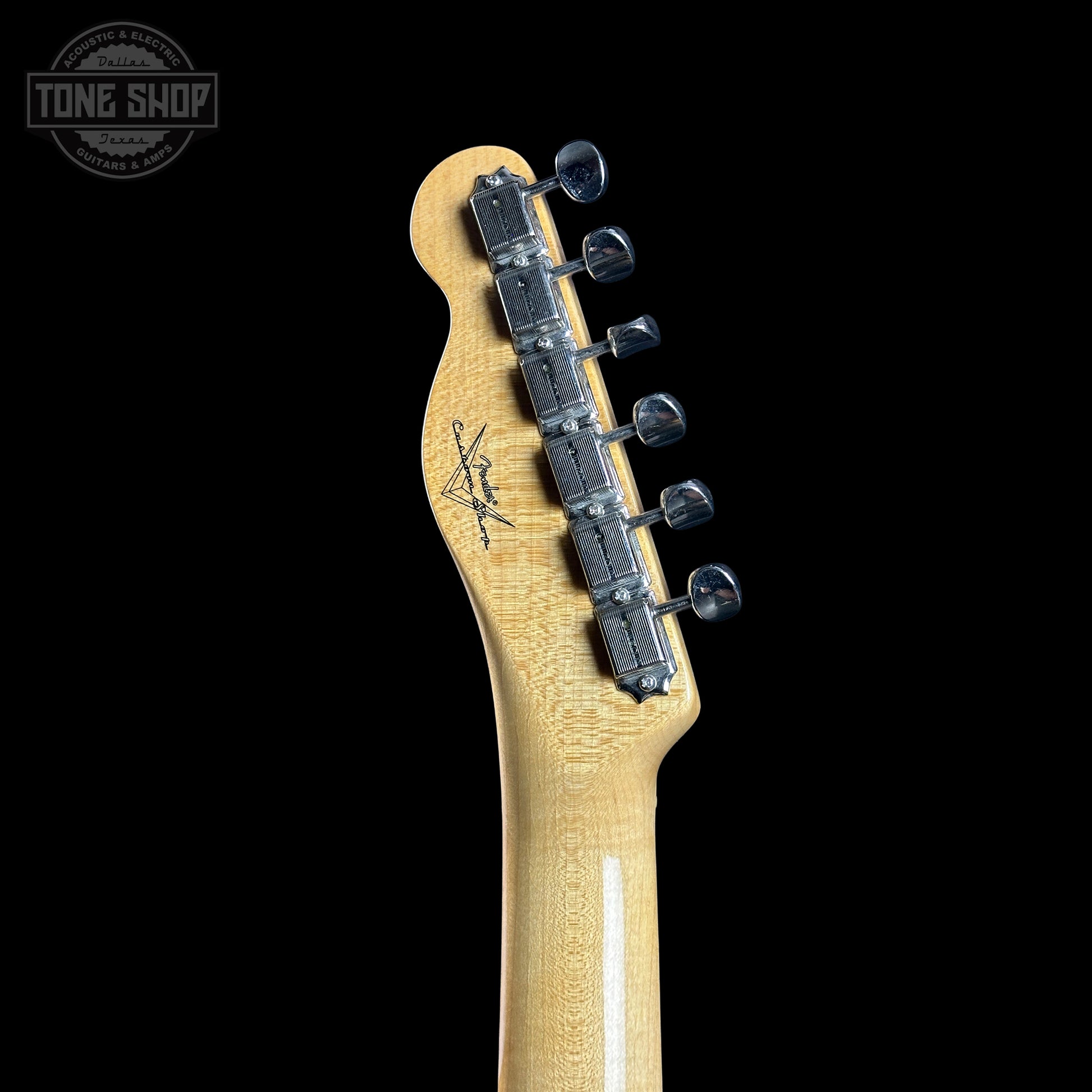 Guitar headstock with tuning pegs on a black background, featuring the Tone Shop logo.