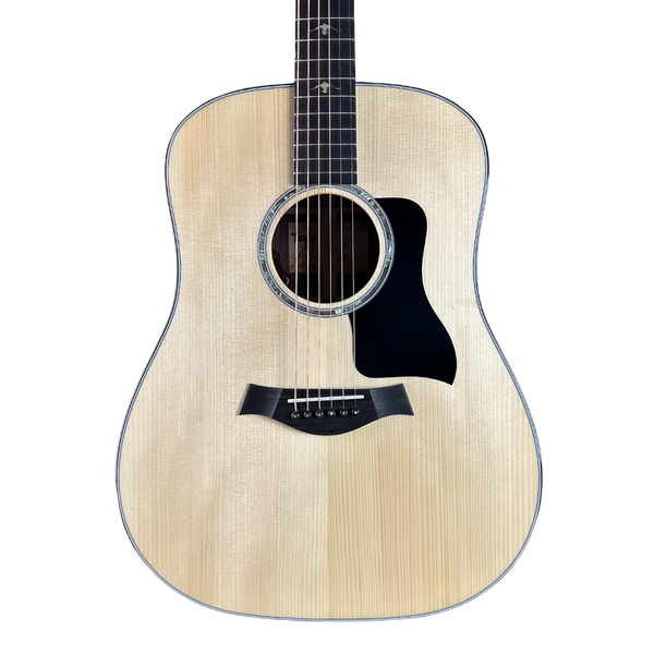 Acoustic guitar with a light wood finish on a white background