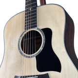 Close-up of an acoustic guitar with a Taylor brand logo on a white background