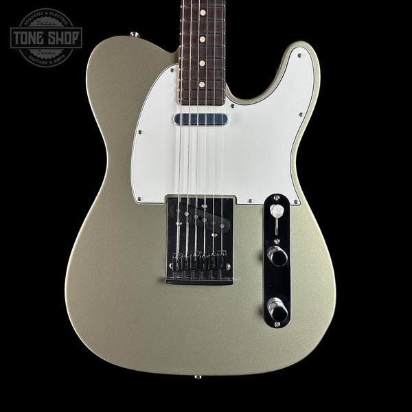 Electric guitar with a silver finish on a black background, featuring the Tone Shop logo.