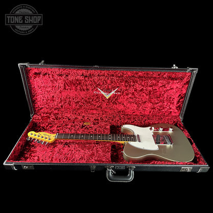 Electric guitar in a red-lined case with a visible brand logo on a black background