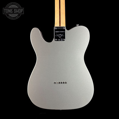 Back view of a silver electric guitar with a black background