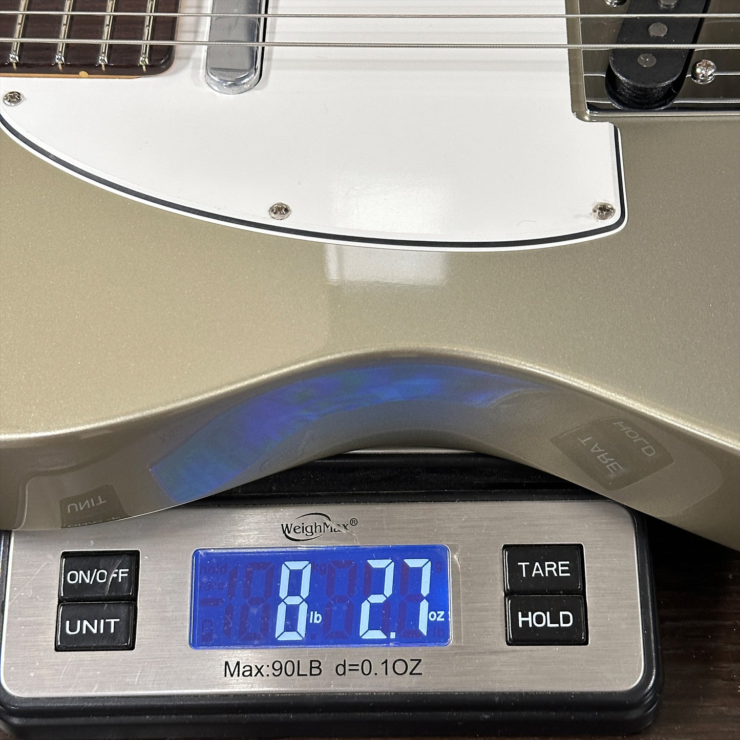 Guitar on a digital scale displaying weight