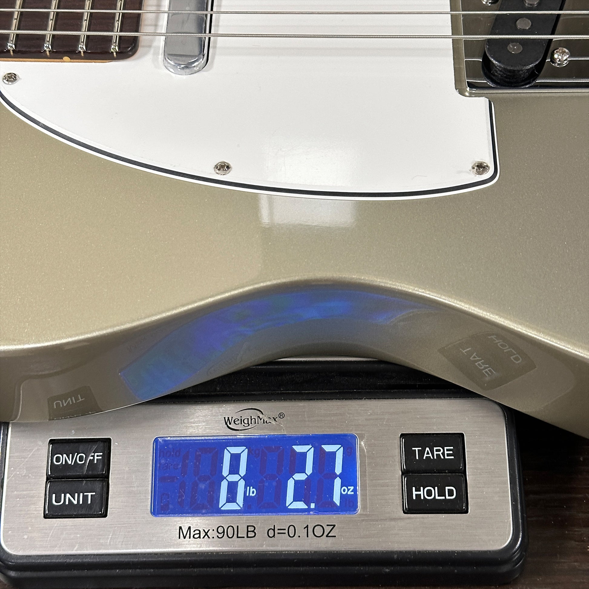 Guitar on a digital scale displaying weight