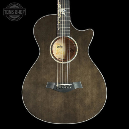 Taylor 2025 Namm Custom Grand Concert 12-Fret Guitar with transparent black color and a case, featuring a sitka spruce top and big leaf maple back and sides.