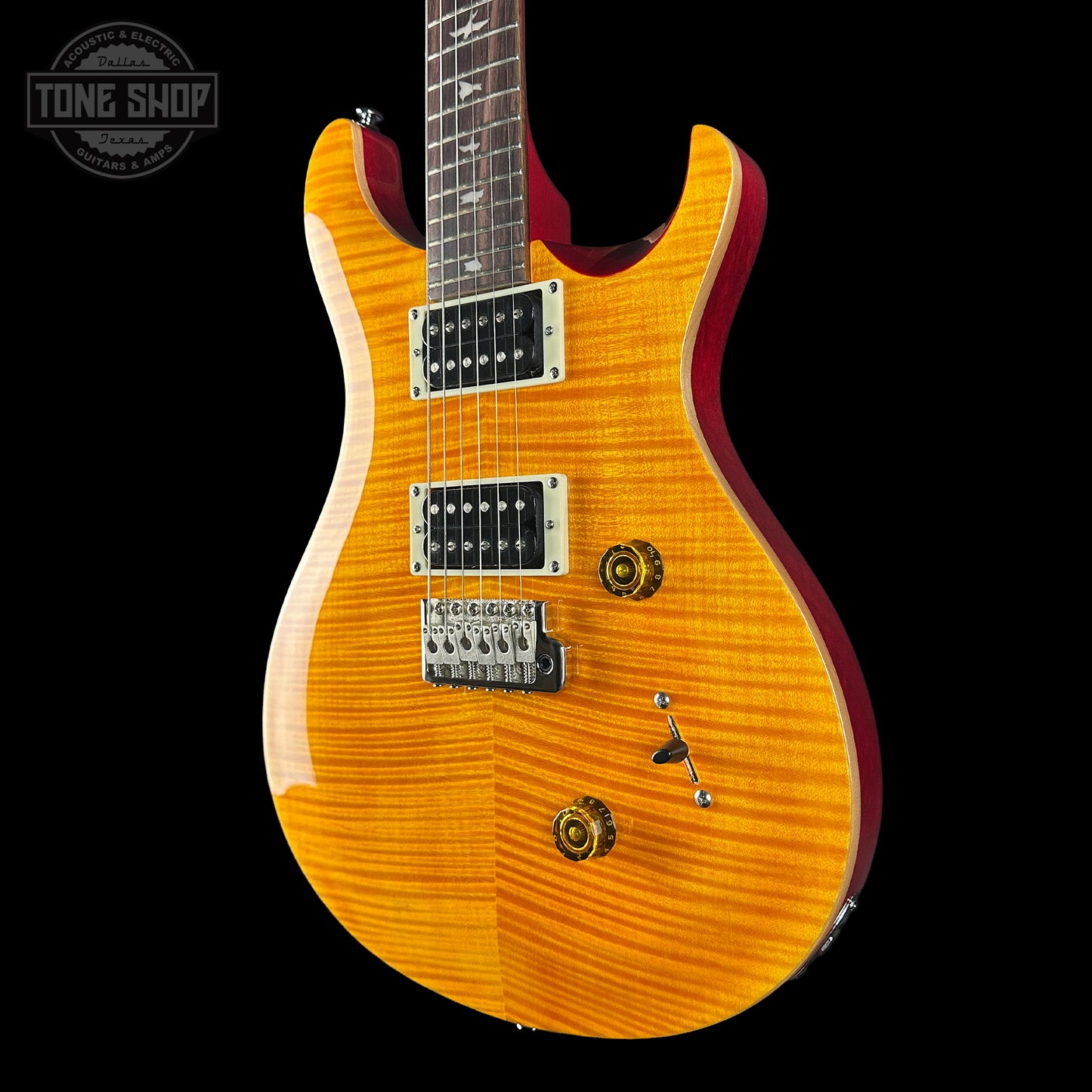 Electric guitar with a sunburst finish on a black background, featuring the Tone Shop logo.