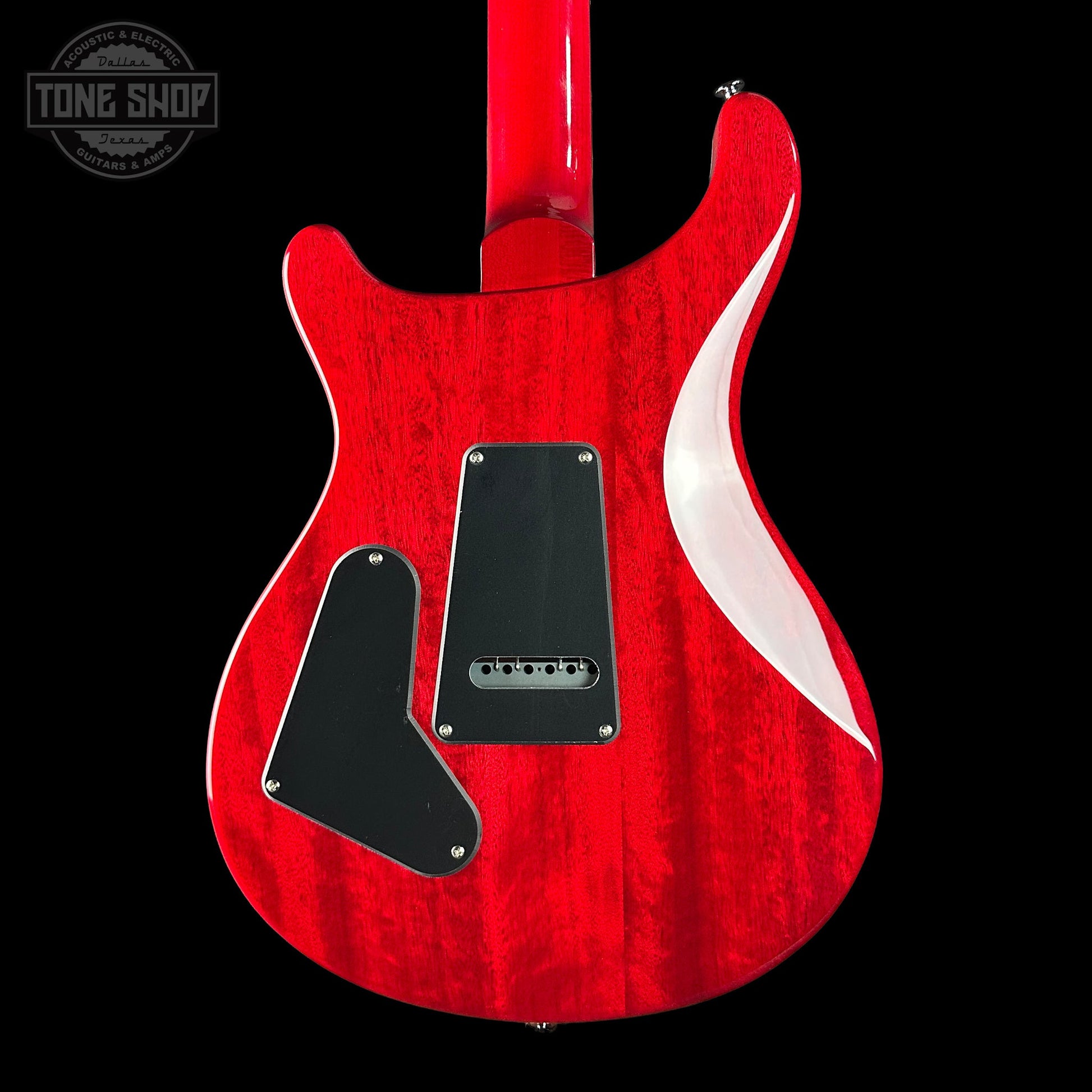 Red electric guitar with a black pickguard on a black background, featuring the Tone Shop logo.