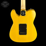 Yellow electric guitar with a visible brand logo on a black background