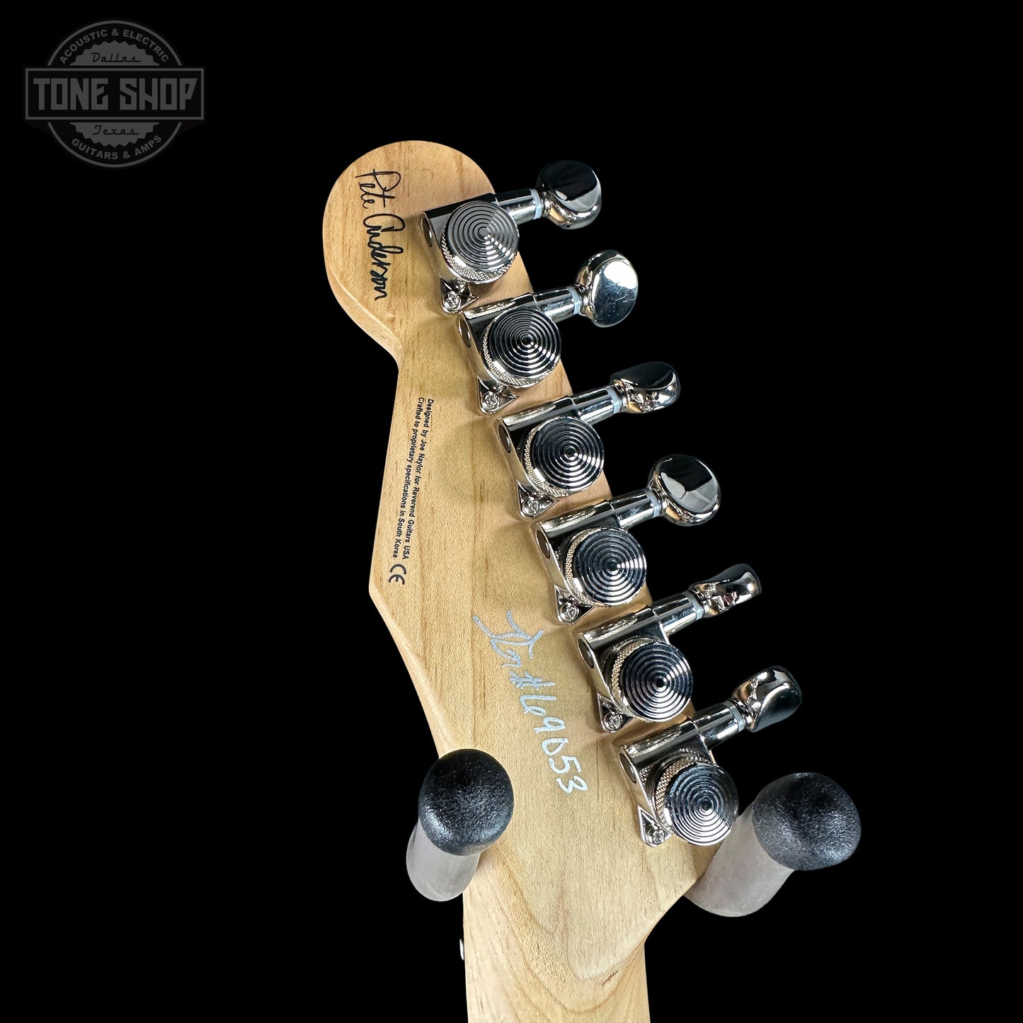 Guitar headstock with tuning pegs on a black background, featuring the Tone Shop logo.