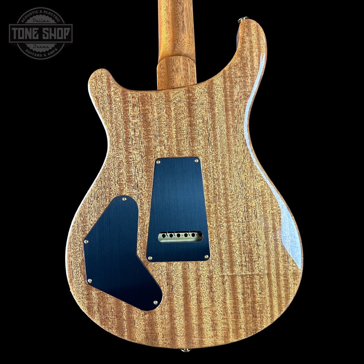 Wooden electric guitar with a blue pickguard on a black background, featuring 'Tone Shop' branding.