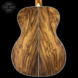 Wooden acoustic guitar back with 'Tone Shop' logo in the corner.
