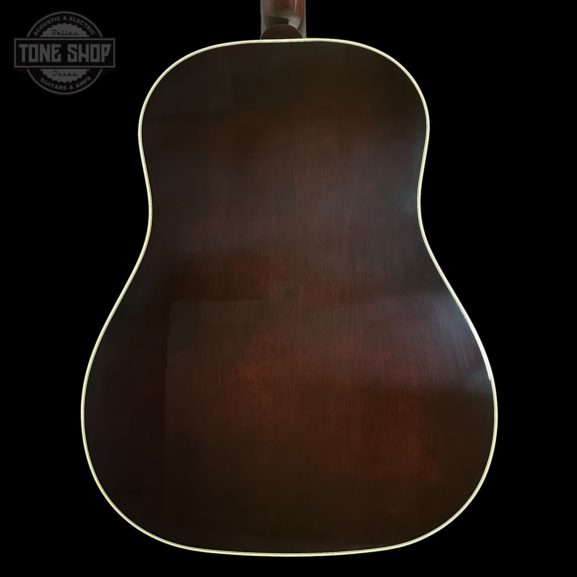 Back of a guitar with a dark brown finish on a black background, featuring the Tone Shop logo.