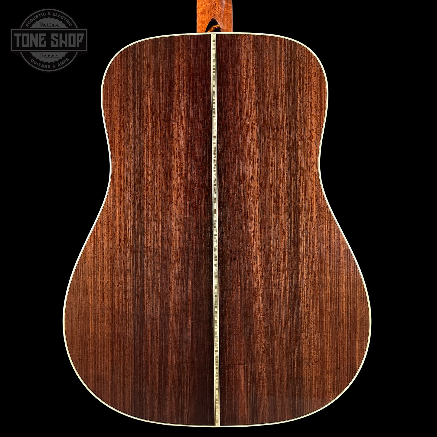 Back view of a wooden acoustic guitar with a visible brand logo in the corner.