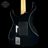 Black electric guitar with a visible brand logo on a black background