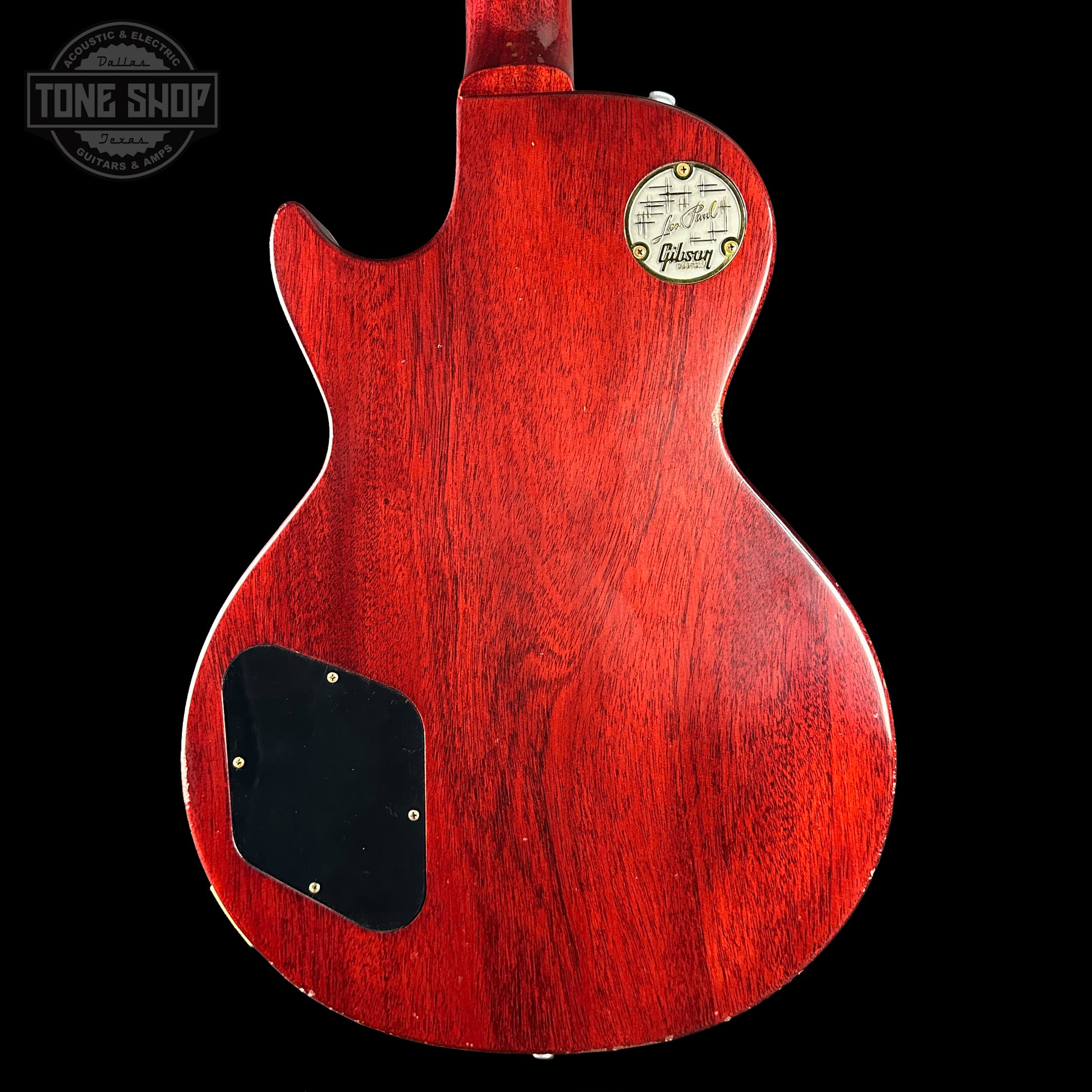 Red Gibson electric guitar body with a visible brand logo on a black background