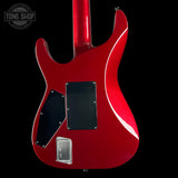 Red electric guitar with a black background, featuring the Tone Shop logo.