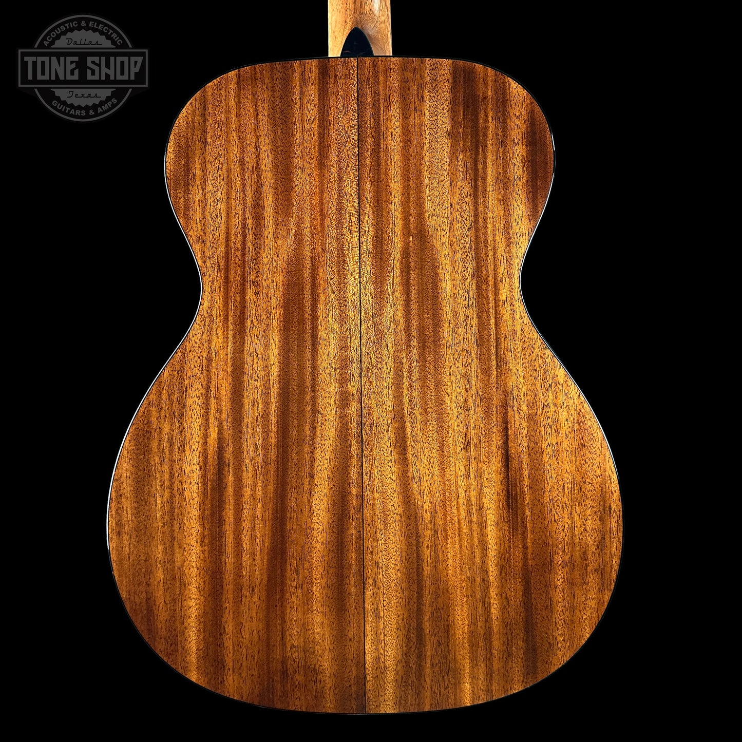 Back view of a wooden acoustic guitar with 'Tone Shop' logo.