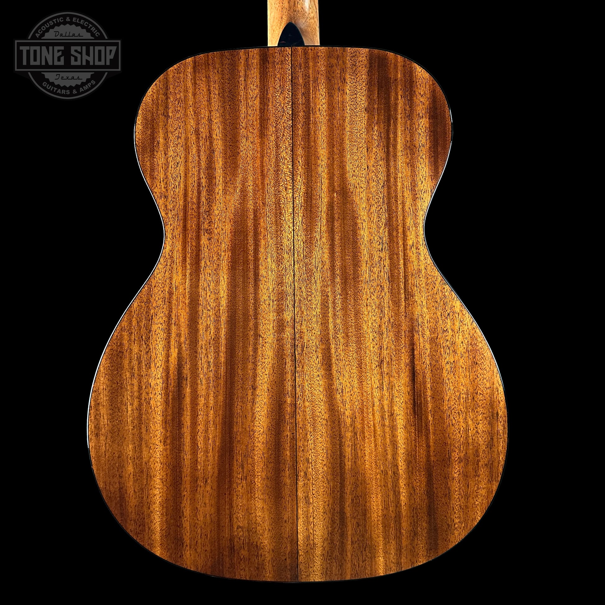 Back view of a wooden acoustic guitar with 'Tone Shop' logo.