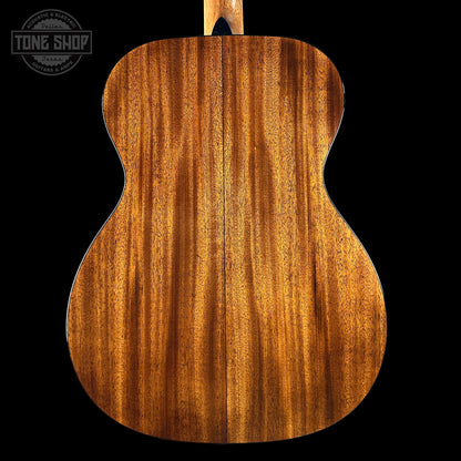 Back view of a wooden acoustic guitar with 'Tone Shop' logo.