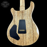 Wooden electric guitar body with a black pickguard on a black background, featuring 'Tone Shop' logo.