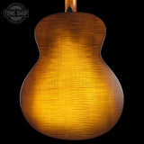 Back view of a wooden acoustic guitar with a dark brown finish on a black background.