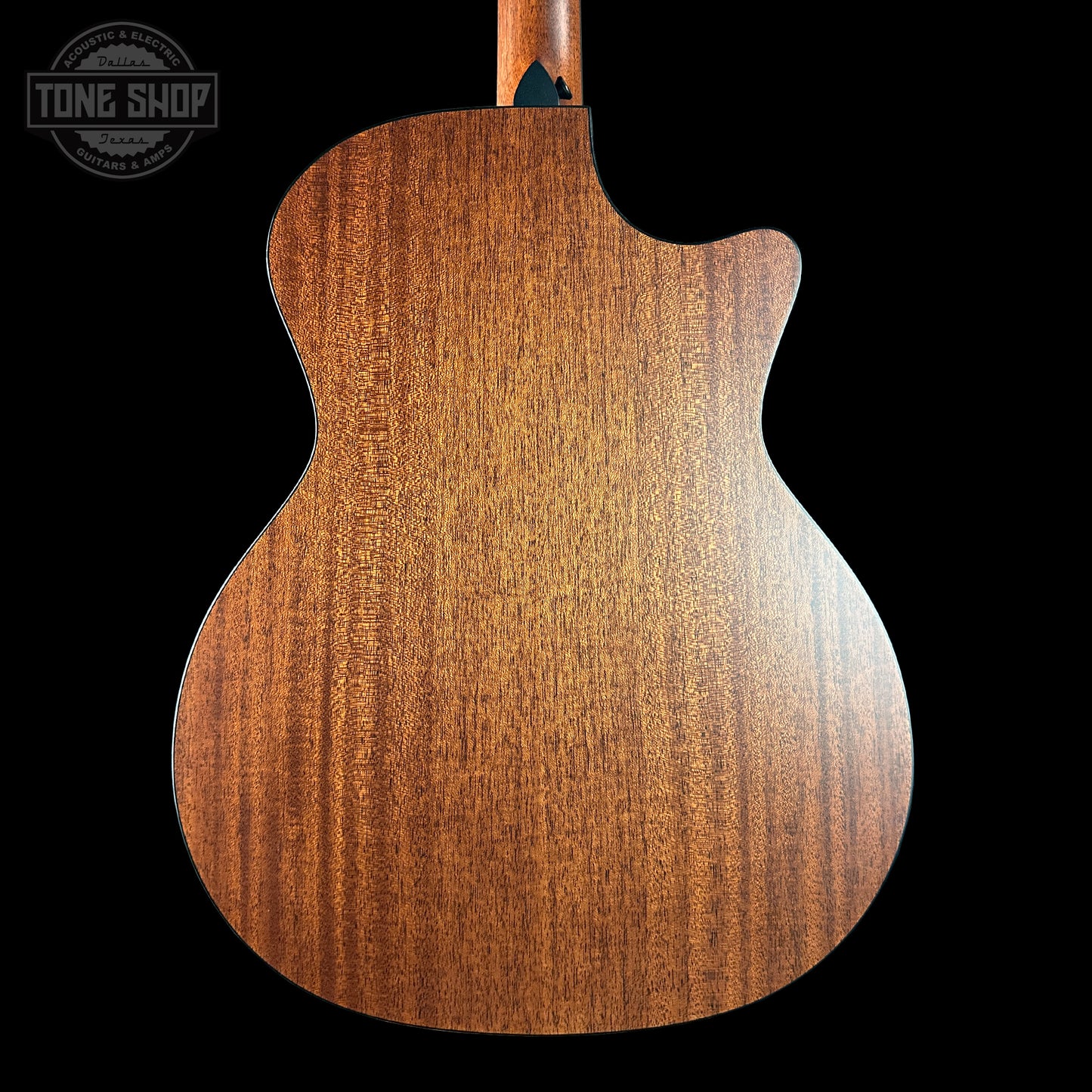 Back view of a wooden guitar with 'Tone Shop' logo in the corner.