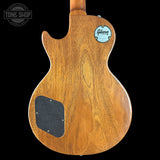 Back view of a wooden guitar with a Gibson logo on a black background