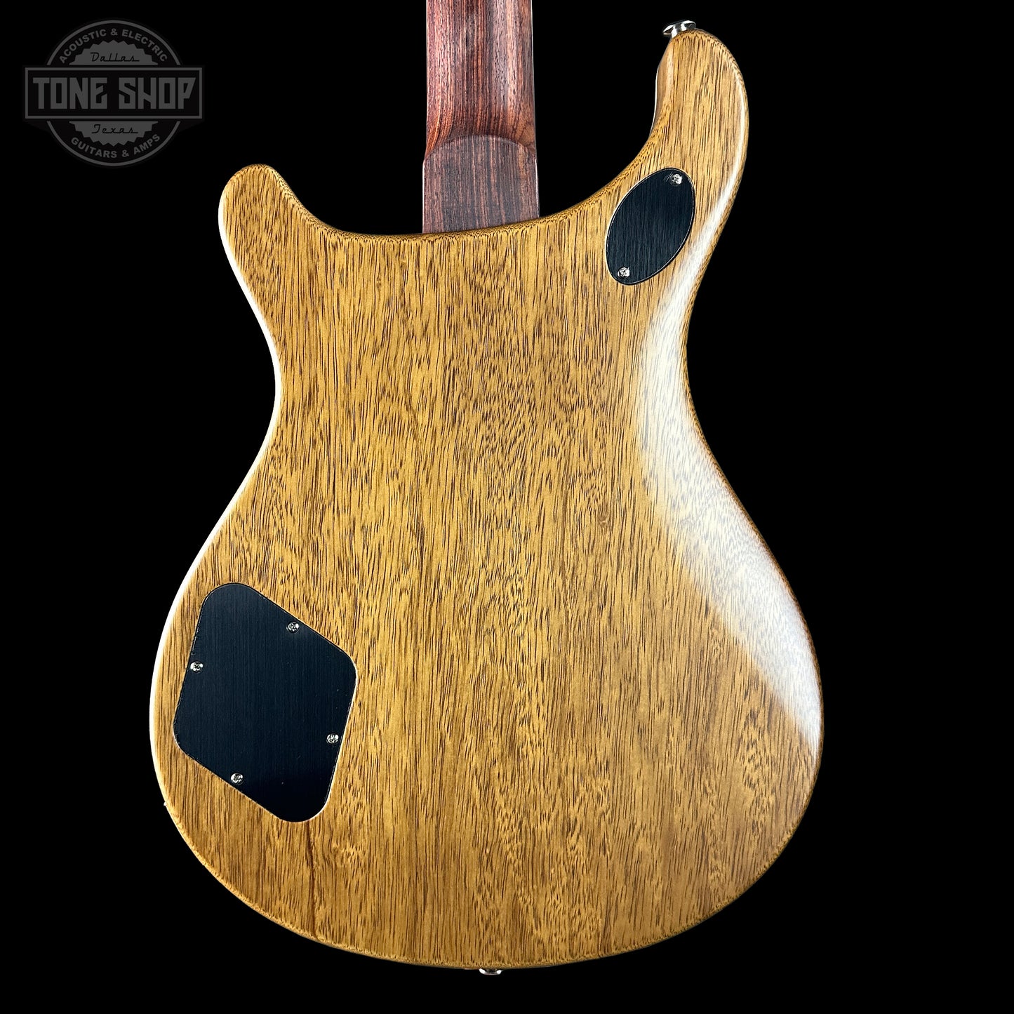 Back of a wooden electric guitar with 'Tone Shop' logo in the corner.