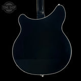 Back view of a black electric guitar with 'Tone Shop' logo.