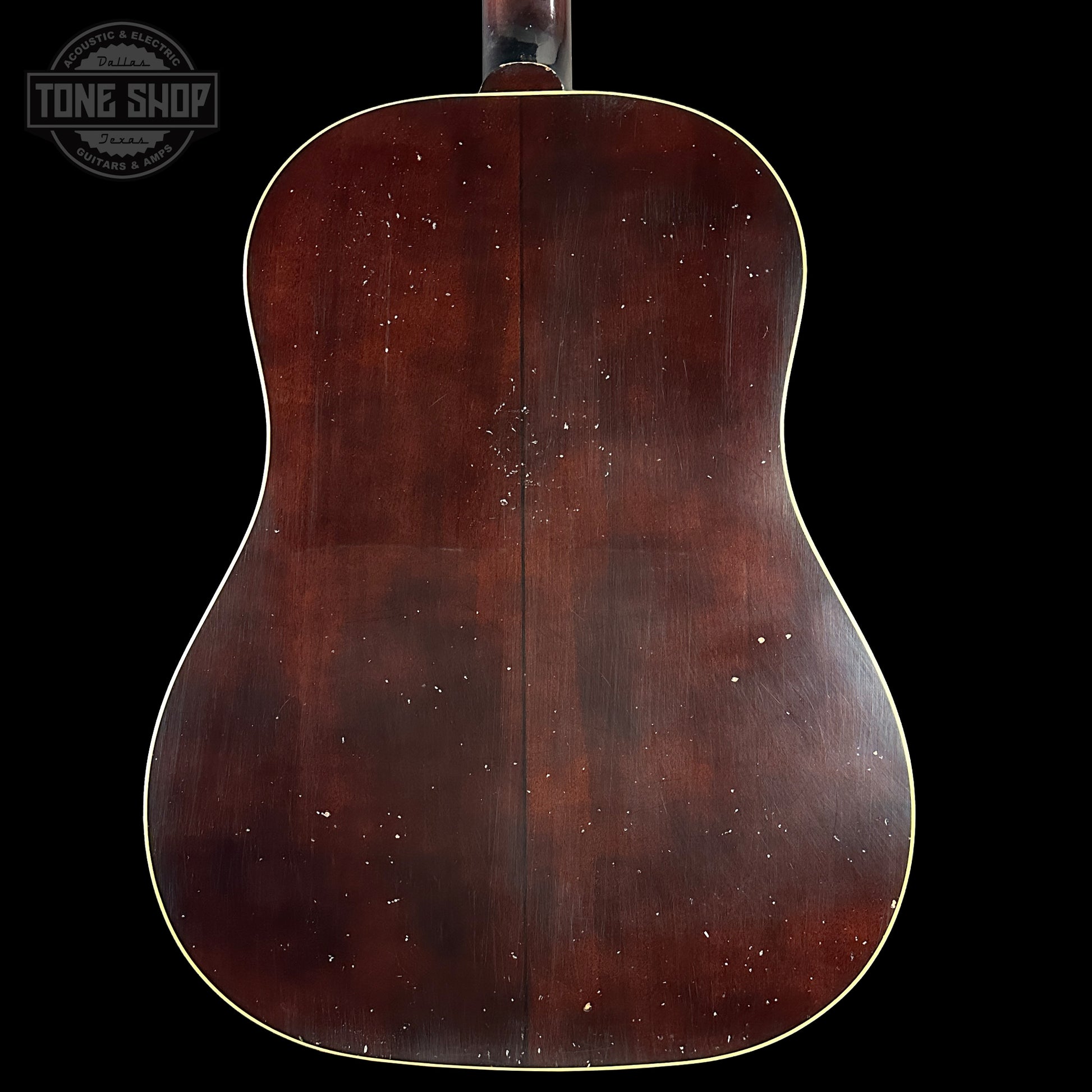 Back view of a wooden acoustic guitar with 'Tone Shop' logo.