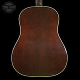 Back view of a wooden acoustic guitar with 'Tone Shop' logo.