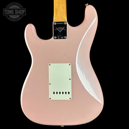 Pink electric guitar with a clear pickguard on a black background, featuring the Fender logo.