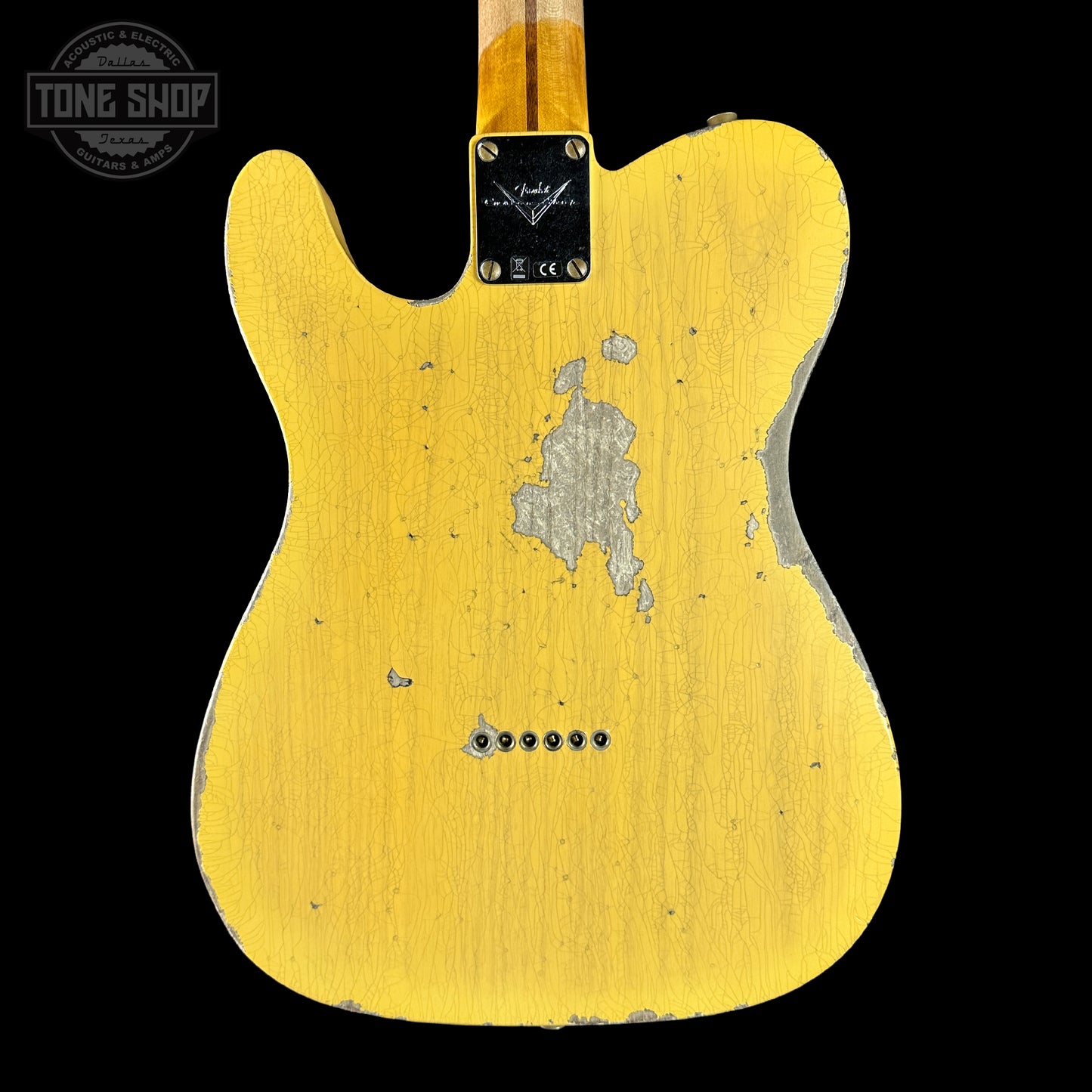 Yellow electric guitar body with visible wear on a black background, featuring 'Tone Shop' logo.