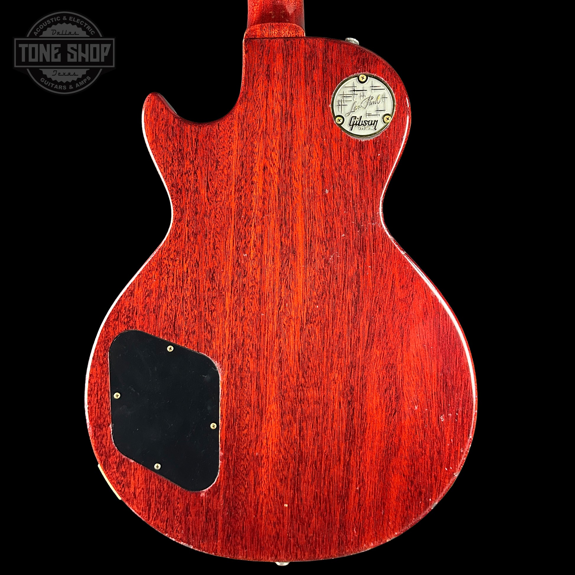 Back view of a red Gibson electric guitar with a visible brand logo on a black background.